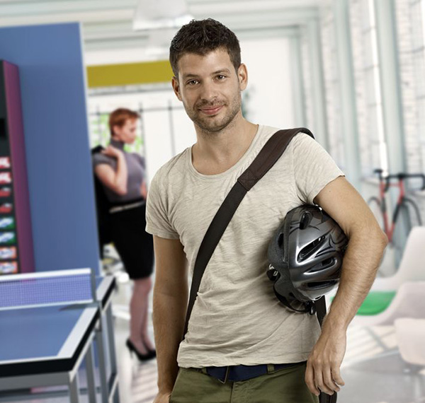 Image of an urban cyclist holding his helmet after a delivery